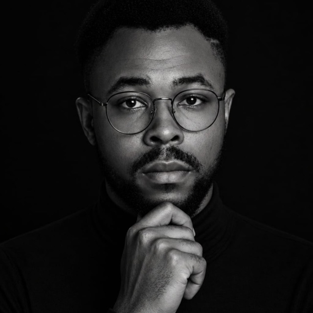 Jason Charles in a black and white portrait, chin resting on his hand