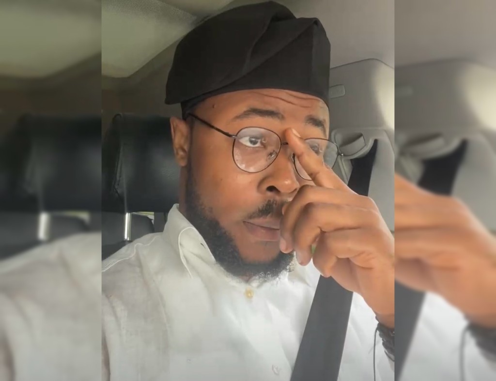 Jason Charles in a white shirt and fila, seated in a car